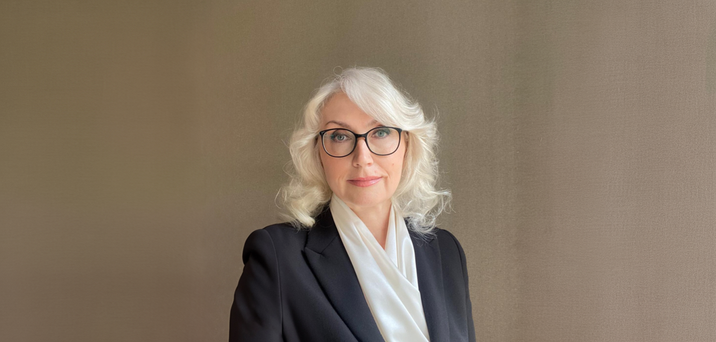 freepik_photo-a-60yearold-white-woman-with-gray-hair-and-glasses-wearing-a-black-blazer-and-a-white-scarf-against-a-plain-brown-background_0001